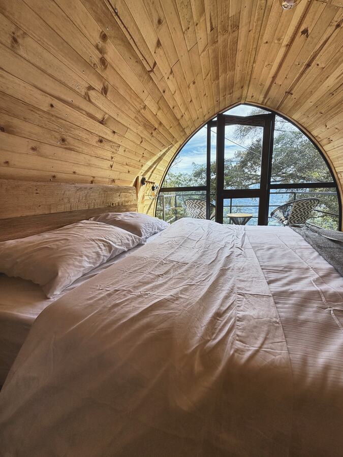Baño en madera con lavamanos y ventana al pasto